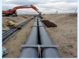Pipe-laying in an excavated corridor at Pulau Tekong.