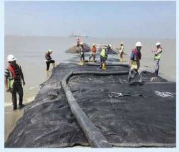 Workers placing geotextile on a polder roadbed at Matarbari, Bangladesh.